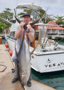 125lb tuna held upright by client back at the dock