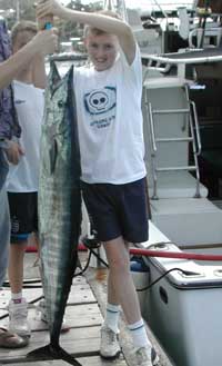 Ollie holds up his wahoo which is as big as he is!