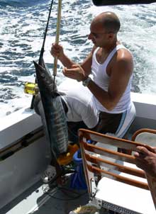 student with his wahoo in the boat