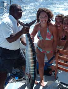 Ashley and friends in bikinis watch as Leslie holds up the wahoo