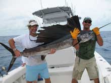 Jake and angler hold up the sailfish recapture